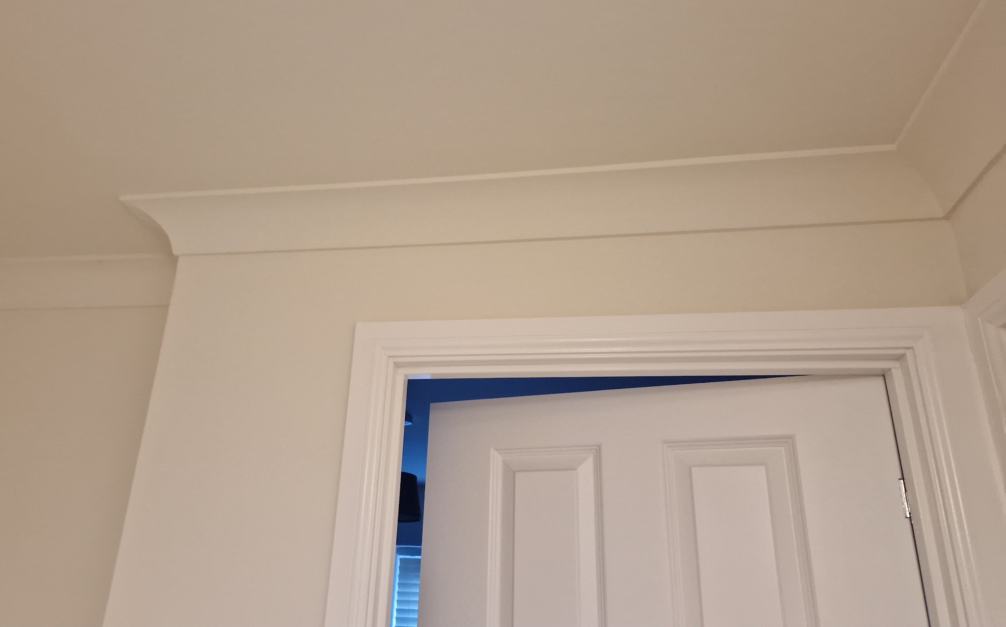 Finished white coving and a door architrave