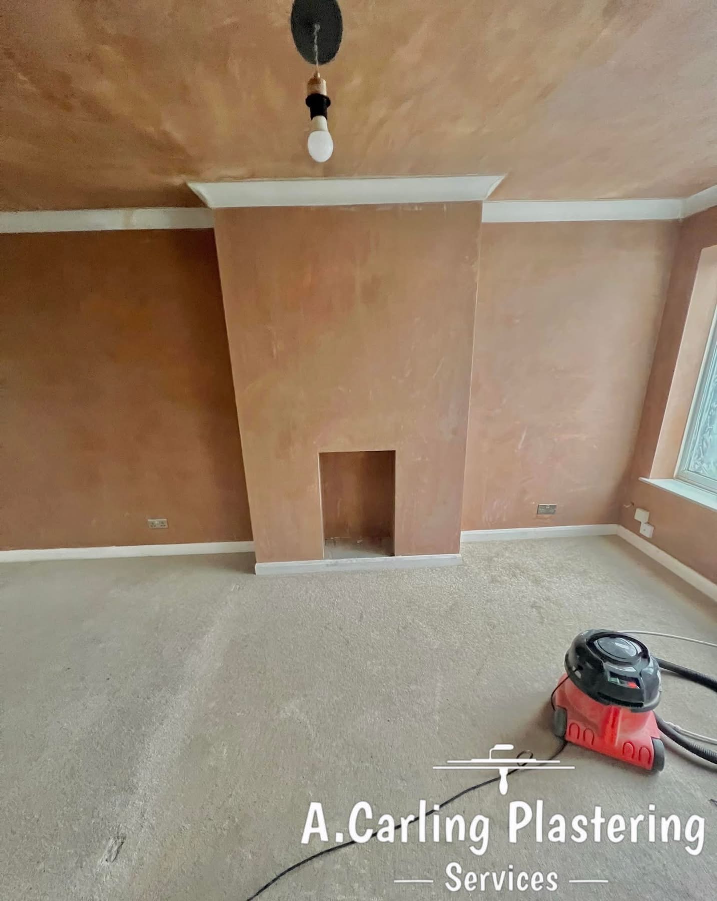 A living room with a freshly skimmed chimney breast and walls in new pink plaster